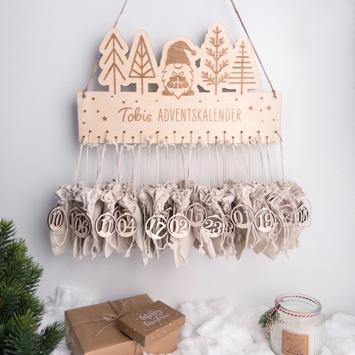 Personalisierter Adventskalender aus Holz mit Wichtel und Tannen, 24 Baumwollsäckchen & runden Zahlenanhängern, zum Befüllen