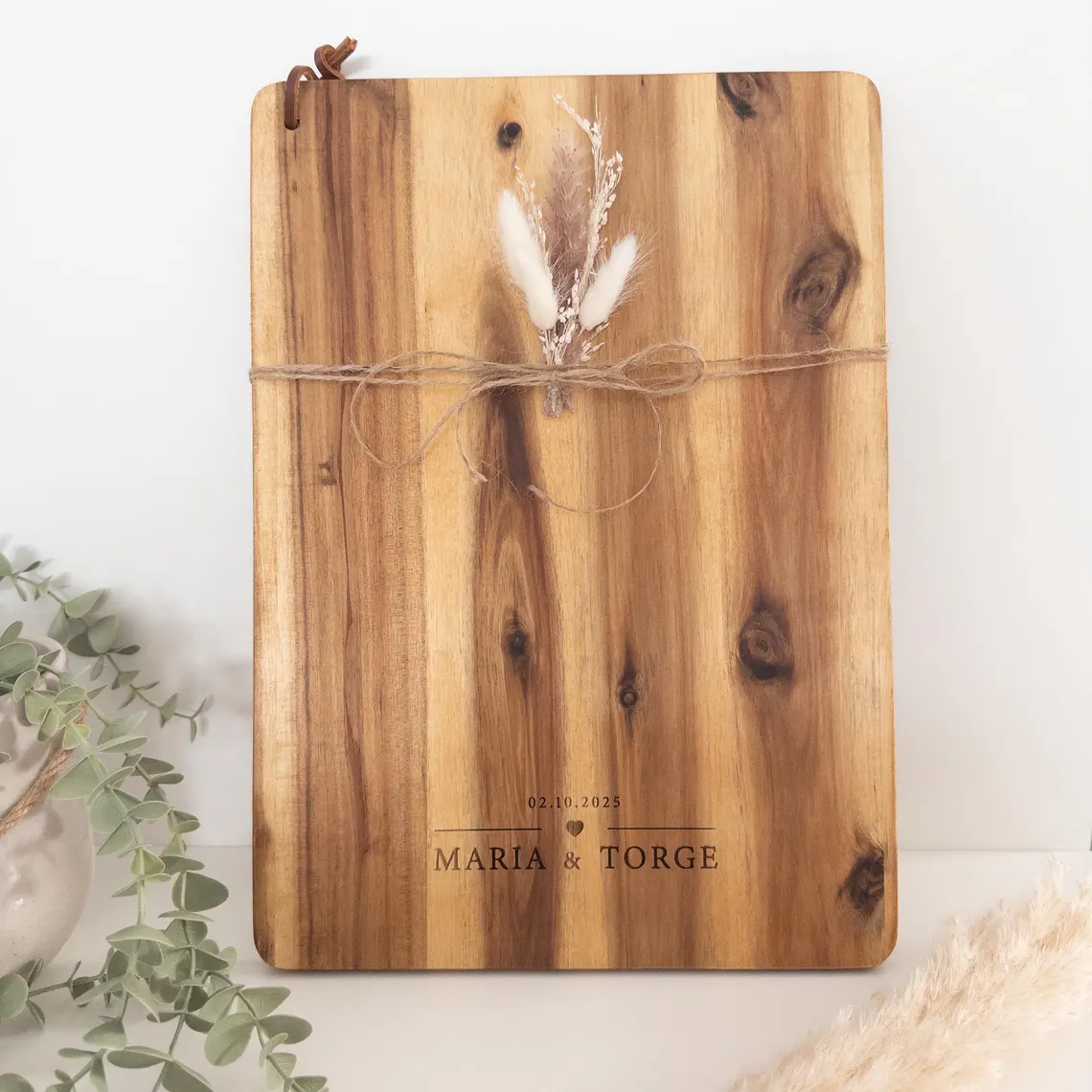 Personalisiertes Schneidebrett mit Namen aus Akazienholz mit Gravur „Maria & Torge – 02.10.2025“, dekoriert mit Juteband und Trockenblumen – Hochzeitsgeschenk.