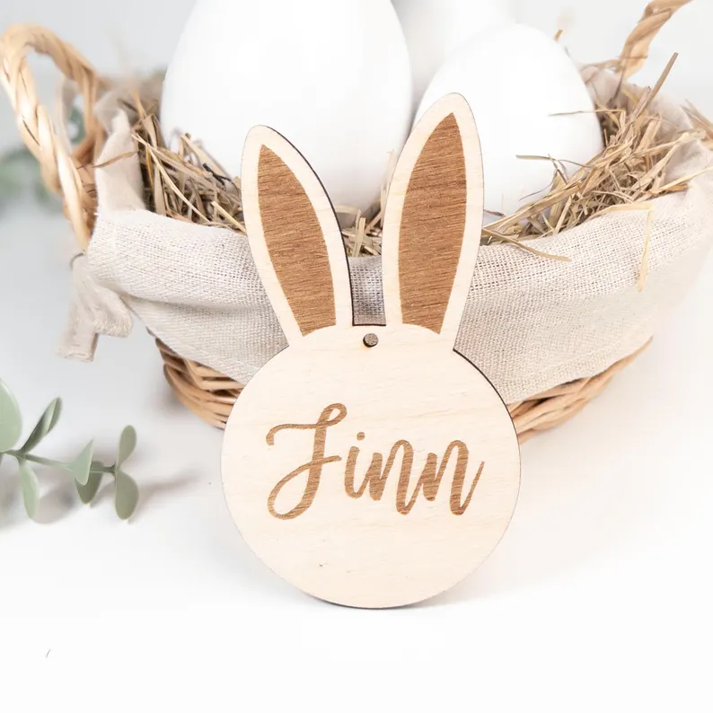 Personalisierter Holz-Osterhase Anhänger mit Name ‚Finn‘ vor Osternest mit Eiern – natürliche Osterdeko